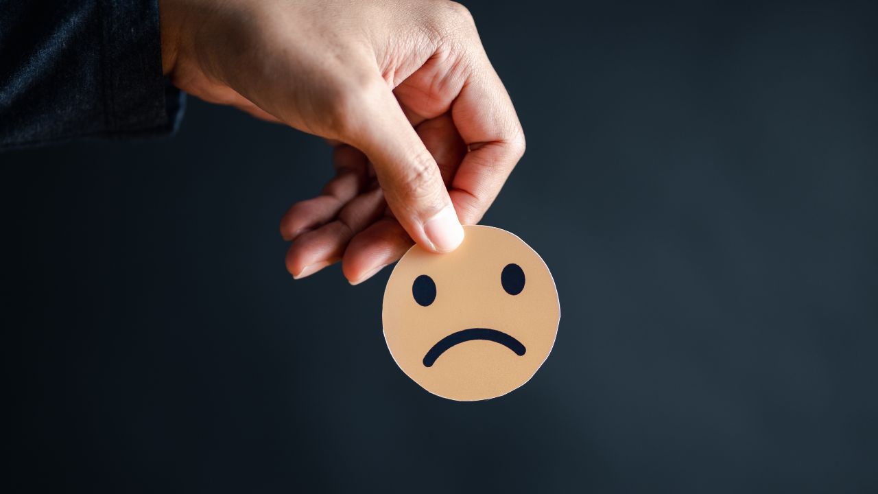 Are you driving customers away? Frownie face being held by a customer