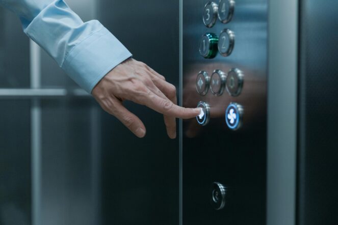 Hand presses elevator buttons. Creating a powerful Elevator pitch