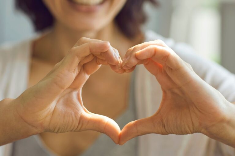 A happy customer makes a heart to signal love with their hands